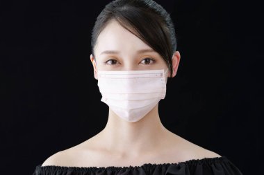 Ten rengine yakın bir maske takan bir kadın.