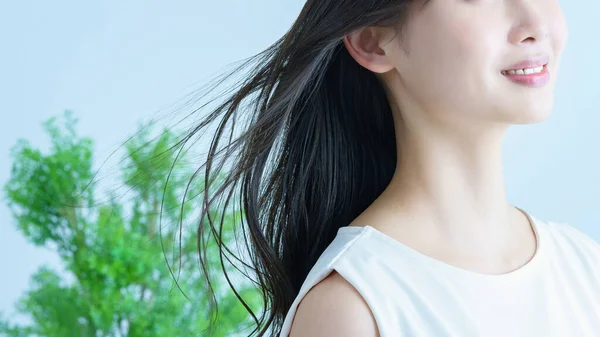 亚洲年轻女子 头发飘扬 面带微笑 — 图库照片