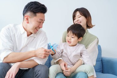 Ebeveynler ve çocuklar koltukta dişlerini fırçalıyorlar.