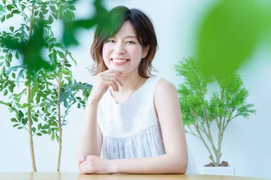 Etrafı bitkilerle çevrili bir kadın.