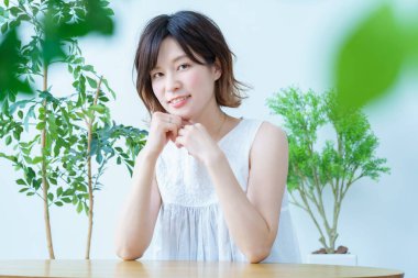 Etrafı bitkilerle çevrili bir kadın.