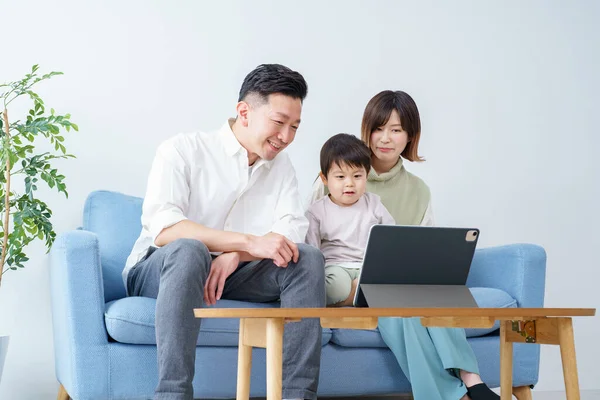 Aile, kapalı alanda bir tabletin ekranına bakıyor.