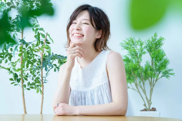 Etrafı bitkilerle çevrili bir kadın.