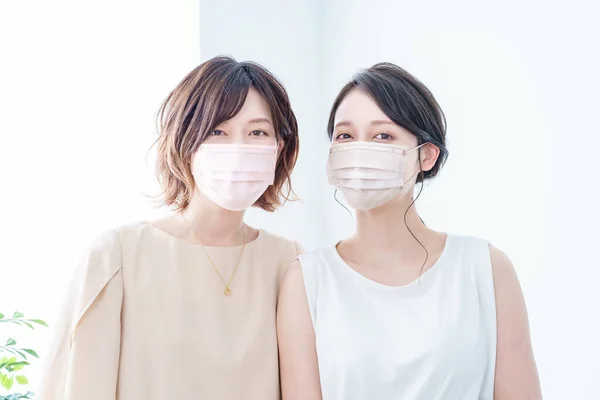 Duas Mulheres Usando Máscaras Com Uma Cor Perto Pele — Fotografia de Stock