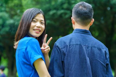 Genç bir çift taze yeşil bir gülümsemeyle yürüyüşe çıkıyor.