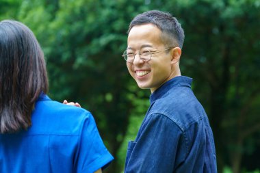 Genç bir çift taze yeşil bir gülümsemeyle yürüyüşe çıkıyor.