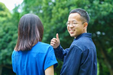 Genç bir çift taze yeşil bir gülümsemeyle yürüyüşe çıkıyor.