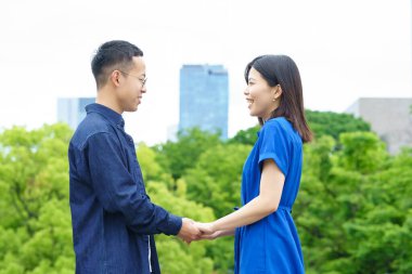 Parkta el ele yürüyen genç bir çift.