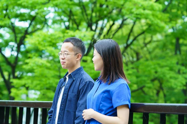 Genç bir çift yeşil bir parkta sohbet ediyor.