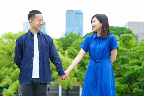 Parkta el ele yürüyen genç bir çift.