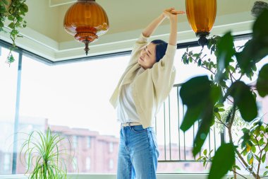 Asyalı kadın odada geriniyor.