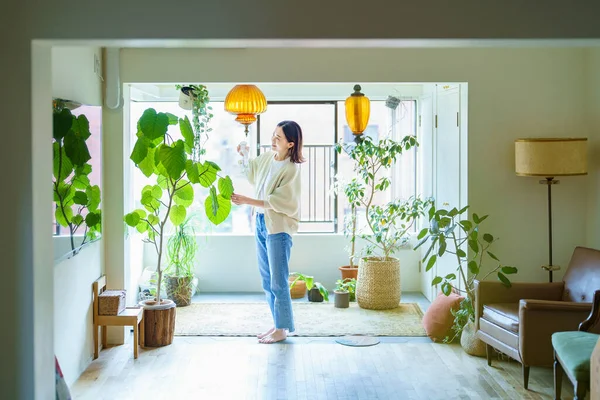 Una Mujer Regando Una Planta Interior Una Habitación —  Fotos de Stock