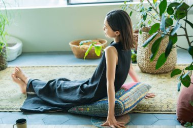 Odada yapraklarla çevrili bir kadın dinleniyor.