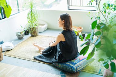 Odada yapraklarla çevrili bir kadın dinleniyor.