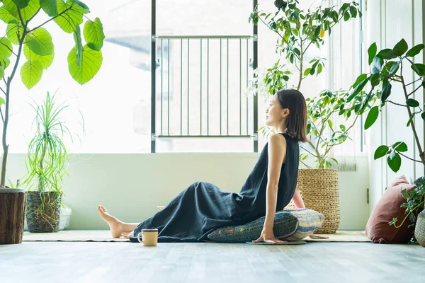 Odada yapraklarla çevrili bir kadın dinleniyor.