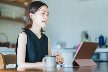 İnternet üzerinden tablet bilgisayar kullanan bir kadın.