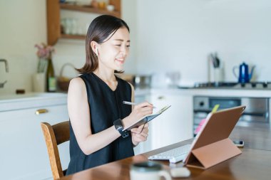 İnternet üzerinden tablet bilgisayar kullanan bir kadın.