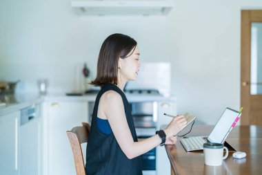 İnternet üzerinden tablet bilgisayar kullanan bir kadın.