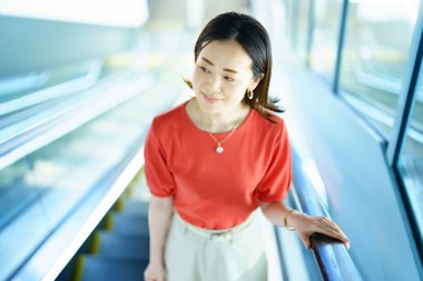 Business woman moving on an escalator in building
