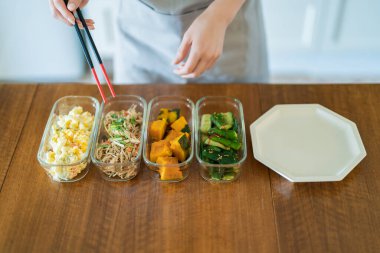 Masaya hazır mezeler koyan bir kadın.