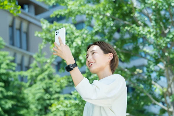 Mujer Joven Sosteniendo Teléfono Inteligente Aire Libre —  Fotos de Stock