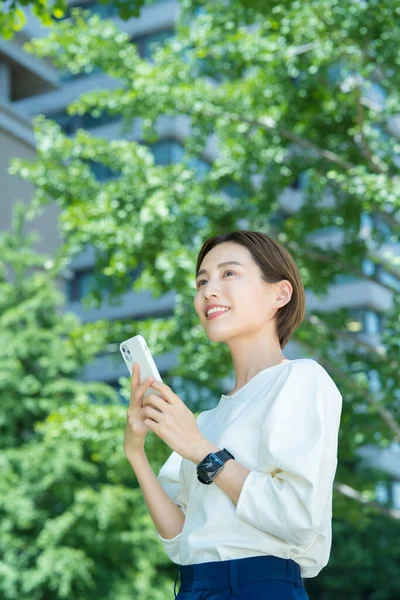 Mujer Joven Sosteniendo Teléfono Inteligente Aire Libre —  Fotos de Stock