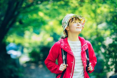 Genç kadın taze yeşil dağda yürüyor.