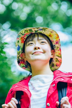 Genç kadın taze yeşil dağda yürüyor.