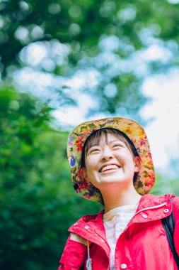 Genç kadın taze yeşil dağda yürüyor.