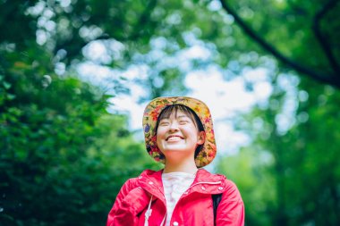 Gözlerini kapayan ve doğayı seven genç bir kadın.