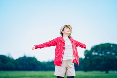 Genç bir kadın çayırda derin bir nefes alıyor.