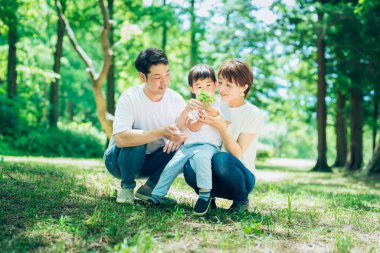 Güzel bir günde ormanda küçük bir saksı bitkisi olan bir aile