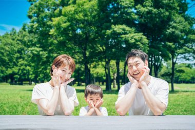 Aile güzel bir günde parkta aynı pozu verir.