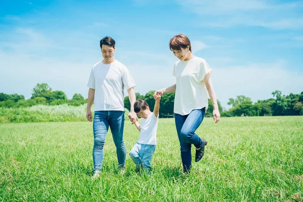 Rodzice Ich Dziecko Trzymają Się Ręce Spacerują Słonecznej Zielonej Przestrzeni — Zdjęcie stockowe