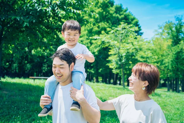 Parents Child Playing Happily While Piggybacking Park —  Fotos de Stock