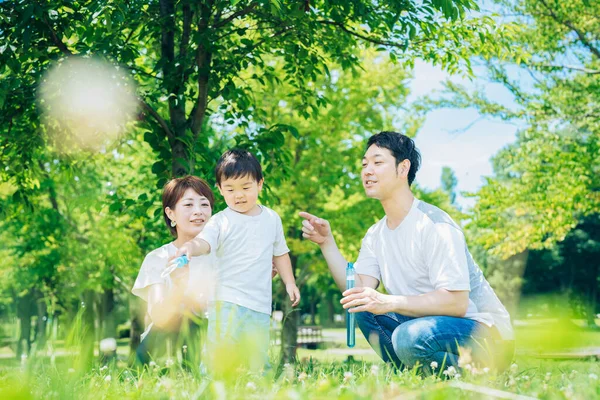 Parents Child Playing Soap Bubbles Park — Fotografia de Stock