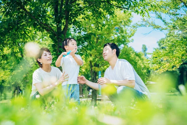 Parents Child Playing Soap Bubbles Park — Fotografia de Stock