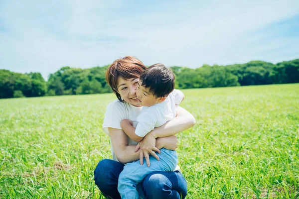 Mother Hugging Her Boy Green Space Fine Day — Stockfoto