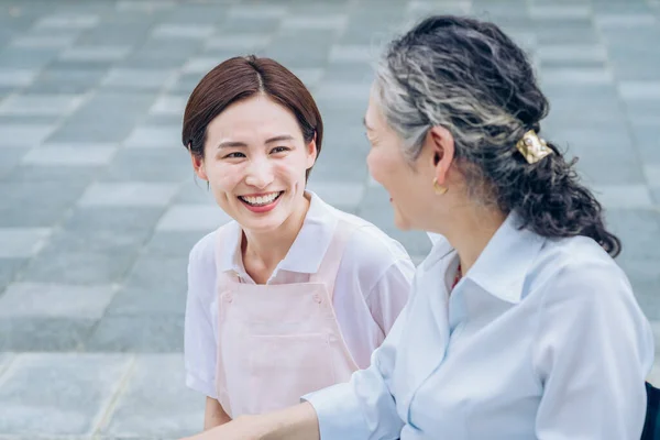 Eine Frau Schürze Gespräch Mit Einer Seniorin Freien — Stockfoto