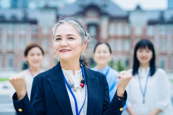 Business Team Centered Gray Haired Woman Outdoors — Stockfoto
