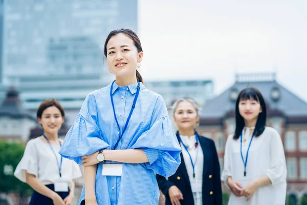 Asian business women lined up outdoors