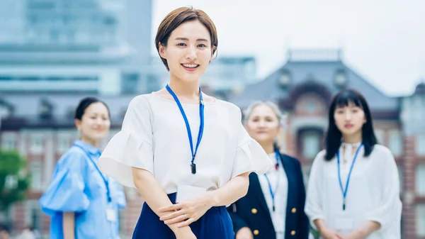 Asian business women lined up outdoors