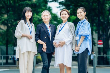 Farklı yaşlardaki kadınlar dışarıda hamile kadınlarla konuşuyorlar.