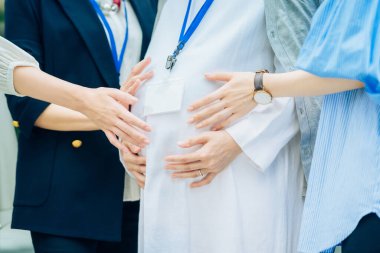 Farklı yaşlardaki kadınlar dışarıda hamile kadınlarla konuşuyorlar.