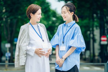 İş kadını dışarıda hamile bir kadınla konuşuyor.