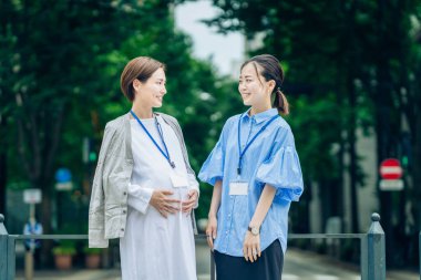 İş kadını dışarıda hamile bir kadınla konuşuyor.