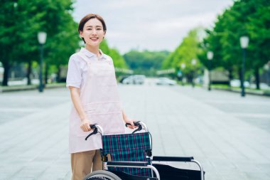 Önlüklü ve tekerlekli sandalyede bir kadın.