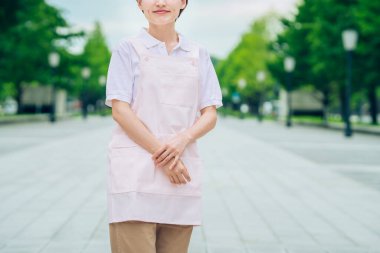 Açık havada önlüklü genç kadın.