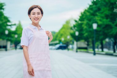 Açık havada önlüklü genç kadın.