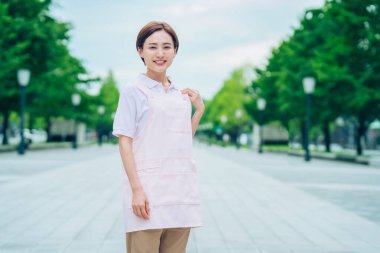 Açık havada önlüklü genç kadın.